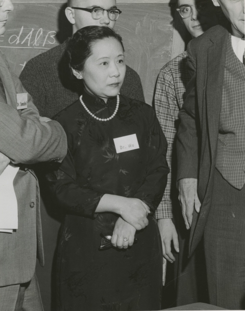 Black and white photo of Chien-Shiung Wu, surrounded by other scientists