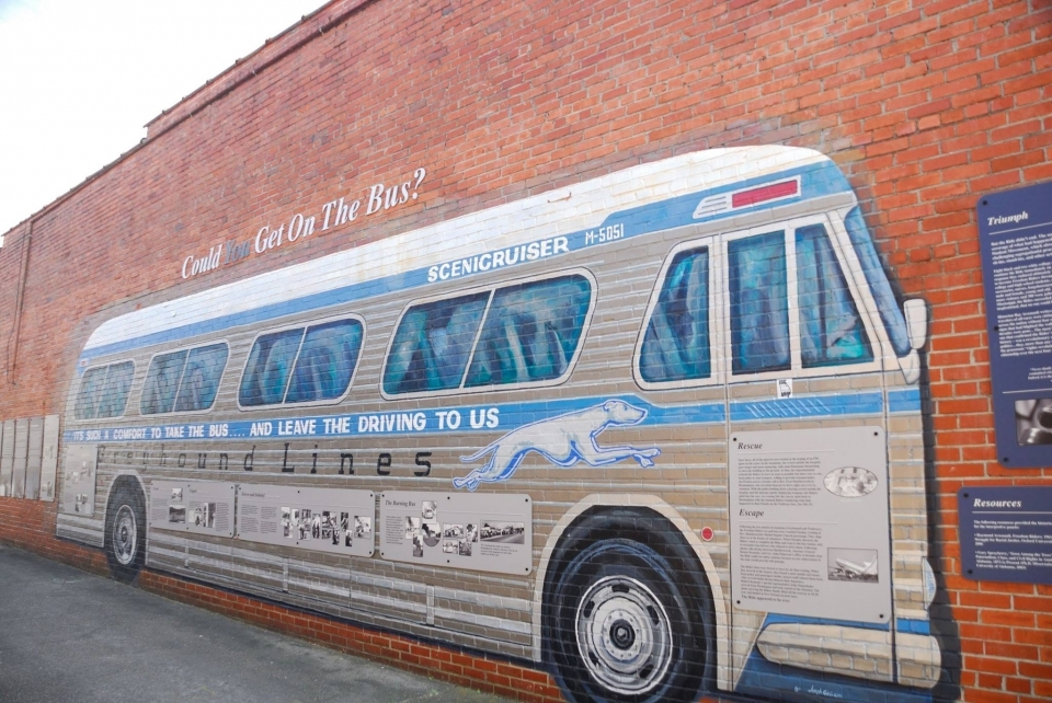 Mural of a Greyhound Bus painted on a brick wall at Freedom Riders National Monument