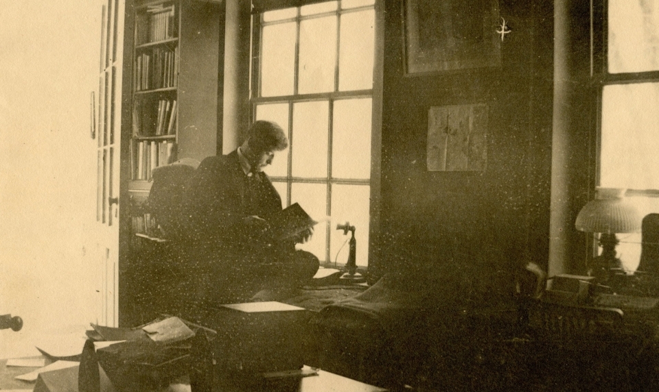 Young man sitting in front of window reading