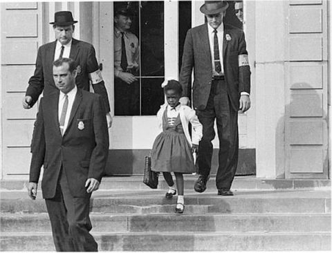 A photograph of young Ruby Bridges being escorted from school in 1960
