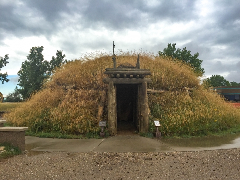 Mound covered in grass with a wooden frame entrance