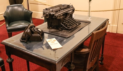 Desk with a telephone, typewriter, and pamphlet on top