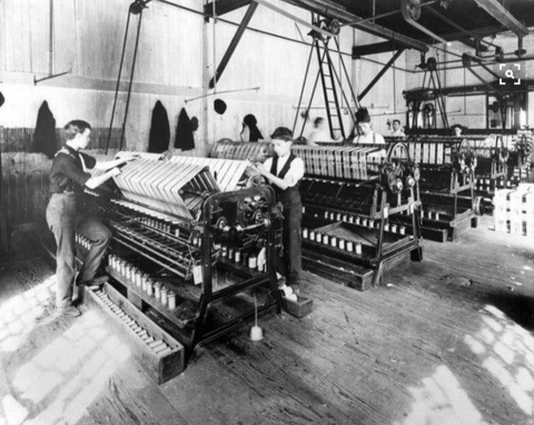 historic black and white photo of a few mill workers at looms