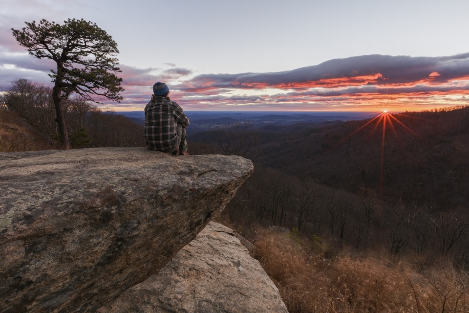 a visitor watches the sun rise on a high overlook