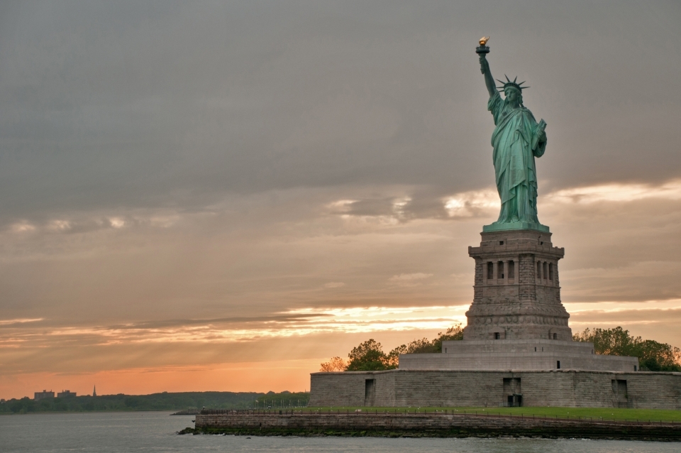Statue of Liberty National Monument against an orange sunset