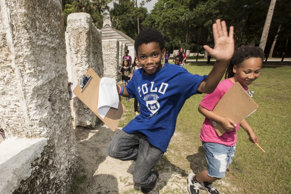child jumping on a field trip to Timucuan Ecological and Historical Park