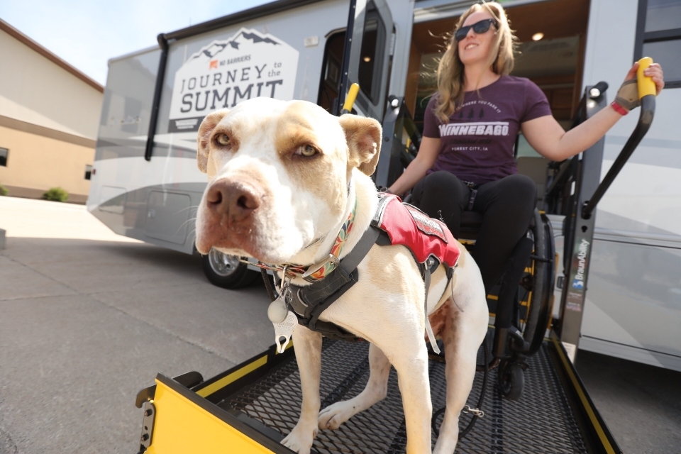 Nerissa Cannon and service dog Cash on wheelchair lift