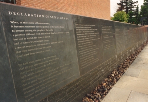 The Declaration of Sentiments and the signers names are written on a blue stone wall, which in summer months, has a calm flow of water flowing over the text.